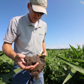 A farmer holds soil in his hands
