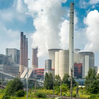 A city skyline in the background with a power plant in the foreground