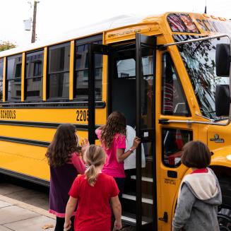 Kids getting on an electric school bus