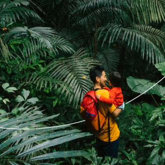 Man holding child in the middle of the rain forest