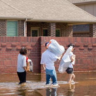 People walking through floodwaters carrying belongings