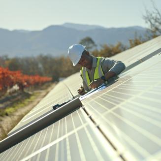 Man working to install solar panels in the countryside