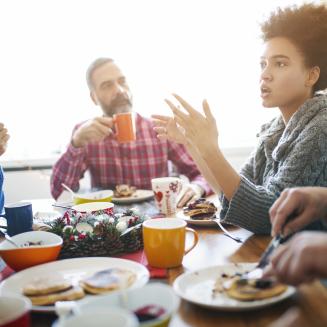 A group of friends or family having a conversation over a meal.