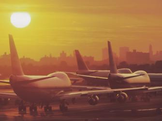 Planes on runway with sunset in background