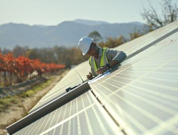 Man working to install solar panels in the countryside